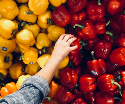 person reaches for peppers